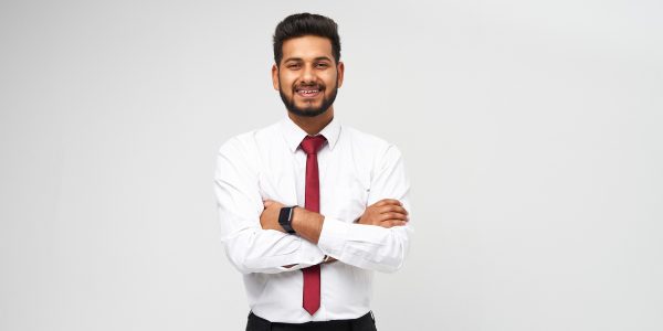 Portrait of young indian top manager in t-shirt and tie crossed arms and smiling on white isolated background Portrait of young indian top manager in t-shirt and tie crossed arms and smiling on white isolated background